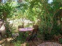 Vue sur la terrasse ombragée et le jardin du relais